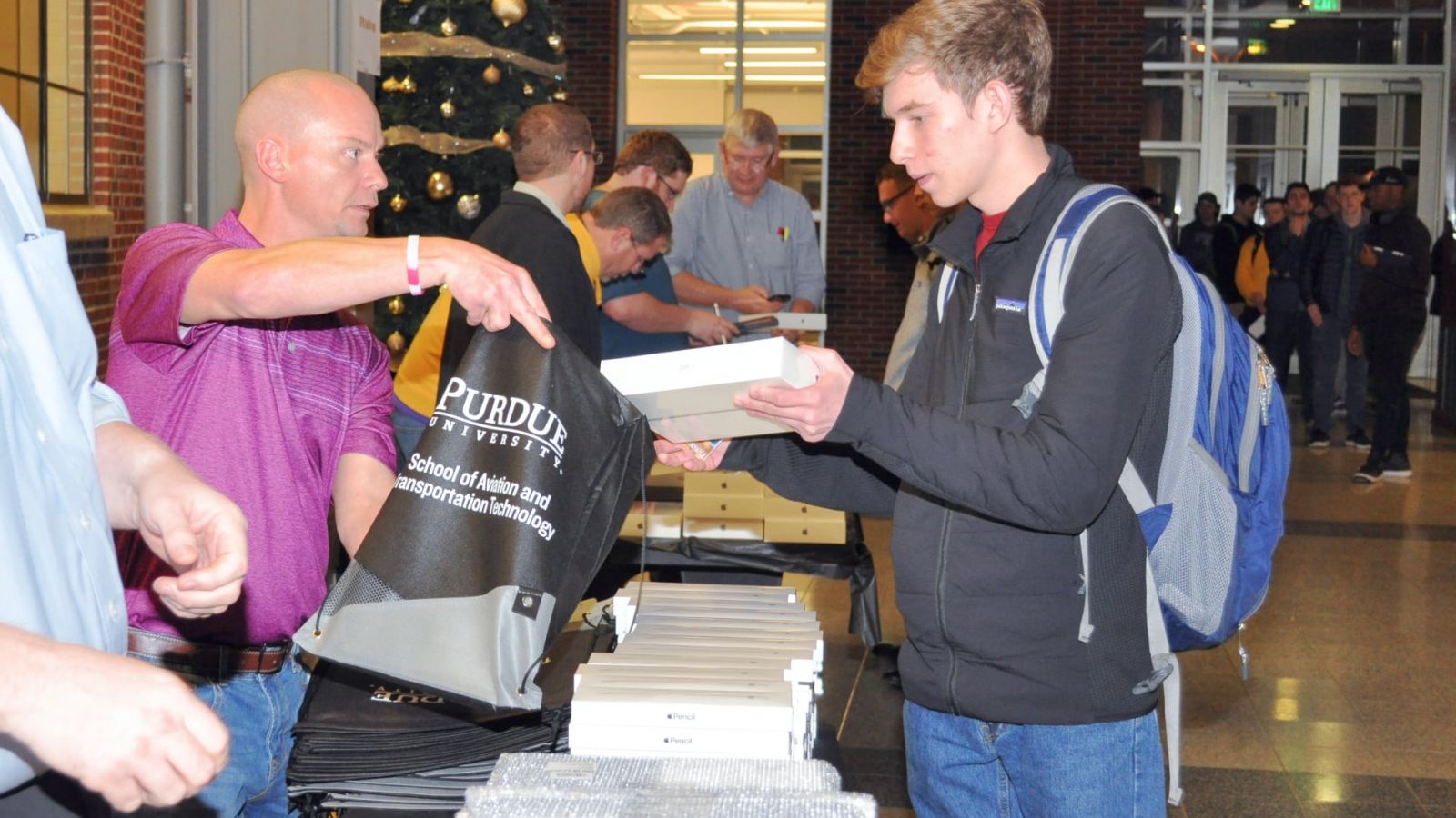 Purdue staff members distribute new Electronic Purdue Bags, each with iPad, Apple Pencil & Logitech keyboards, to students in the School of Aviation and Transportation Technology