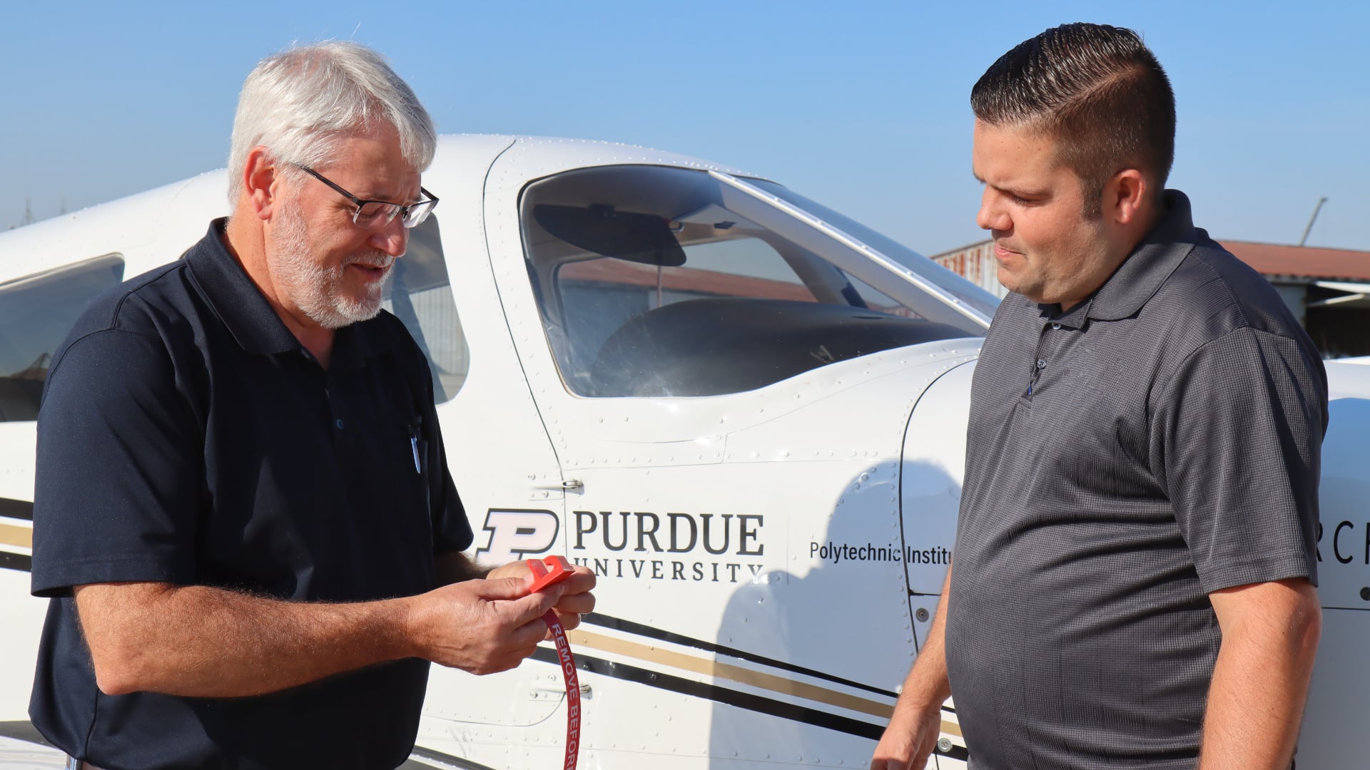 Michael Davis, left, and Jon Ziulkowski have designed a safety guard that fits over the magneto switch of Piper Archer aircraft in Purdue University’s fleet. (Purdue University photo/John O’Malley)