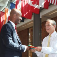 Dawit Lemma, founder and CEO of Krimson Aviation, presents the Ethiopian flag to Tom Frooninckx, interim head of Purdue’s School of Aviation and Transportation Technology, for Purdue’s Niswonger Aviation Technology Building to commemorate the scholarship announcement.