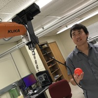 The hitter, a Kuka KR10 robot, stares down Lin Zhang, the pitcher.