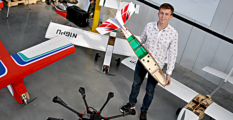 Evan Flatt with the UAVs he has built, modified and/or designed for Purdue research projects.