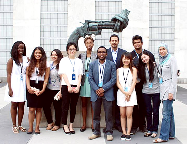 Lin Qian and her fellow interns gather around Non-Violence, a sculpture by Carl Fredrik Reuterswärd, in front of the United Nations.