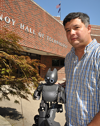 PhD student Mauricio Gomez works with robots, including humanoid Darwin robots.