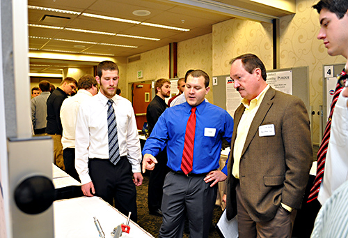 Students provide a project update during a December 2014 poster session.