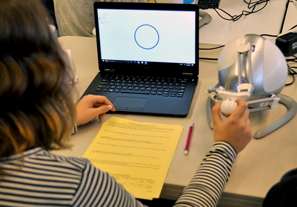 A student explores electric forces by using only haptic feedback on a ring charge simulation.