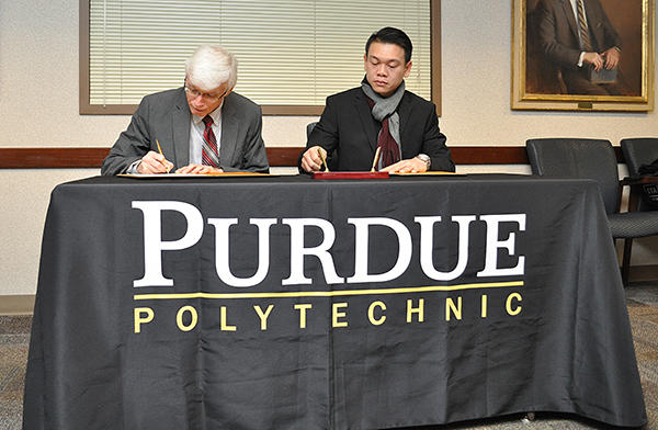 Gary Bertoline, dean, and Zularisam Ab Wahid, dean of the faculty of engineering technology at UMP, sign a letter of intent.
