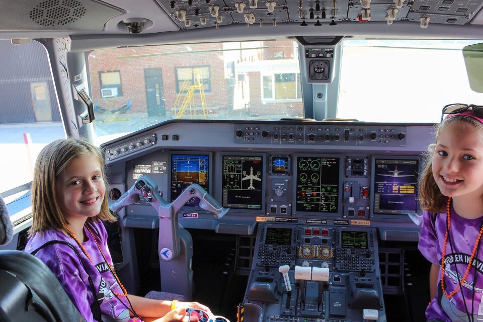 Girls sit in the cockpit a jet at the Purdue Airport