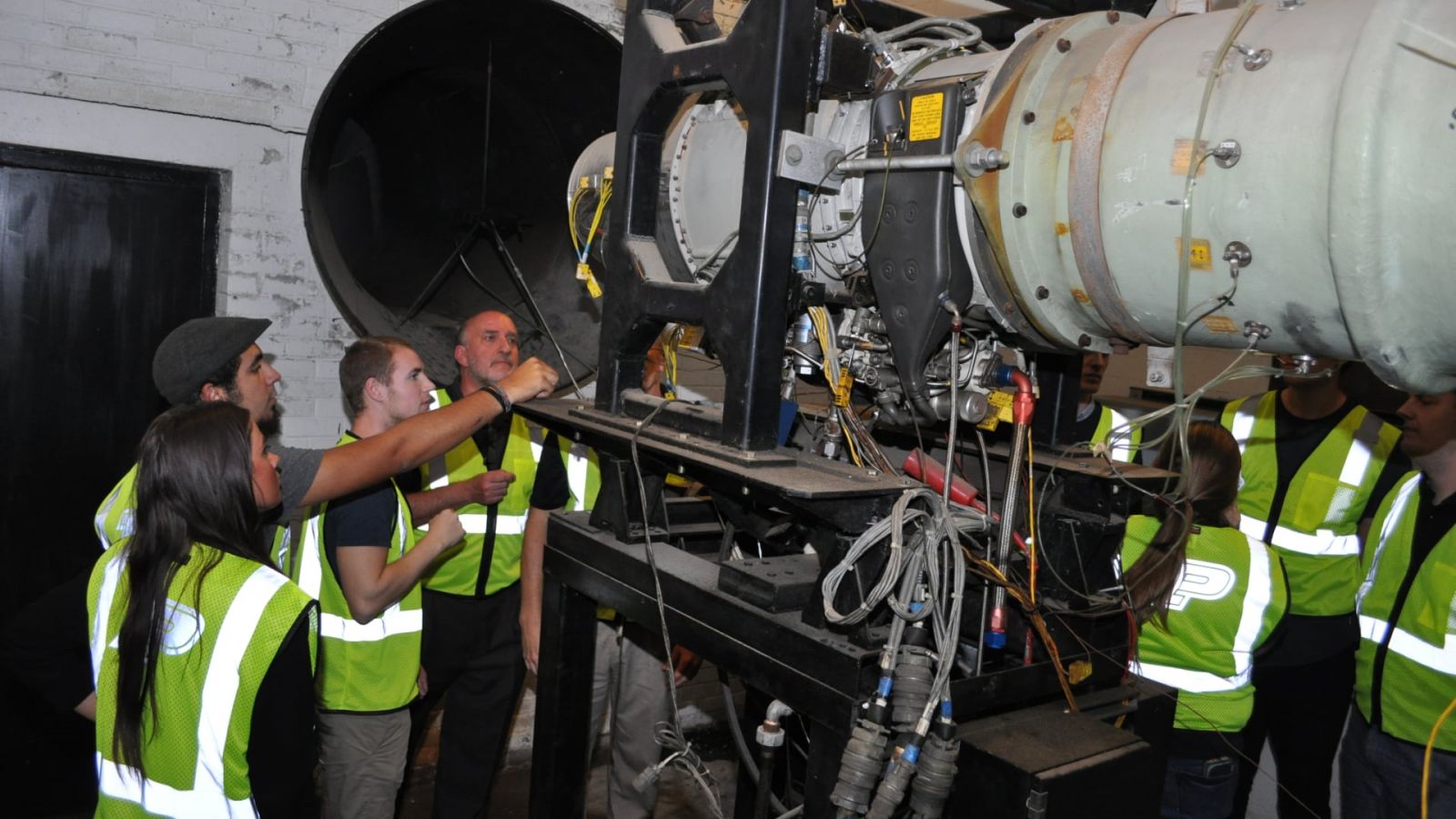 Students and instructors examine the Garrett F109 turbofan engine