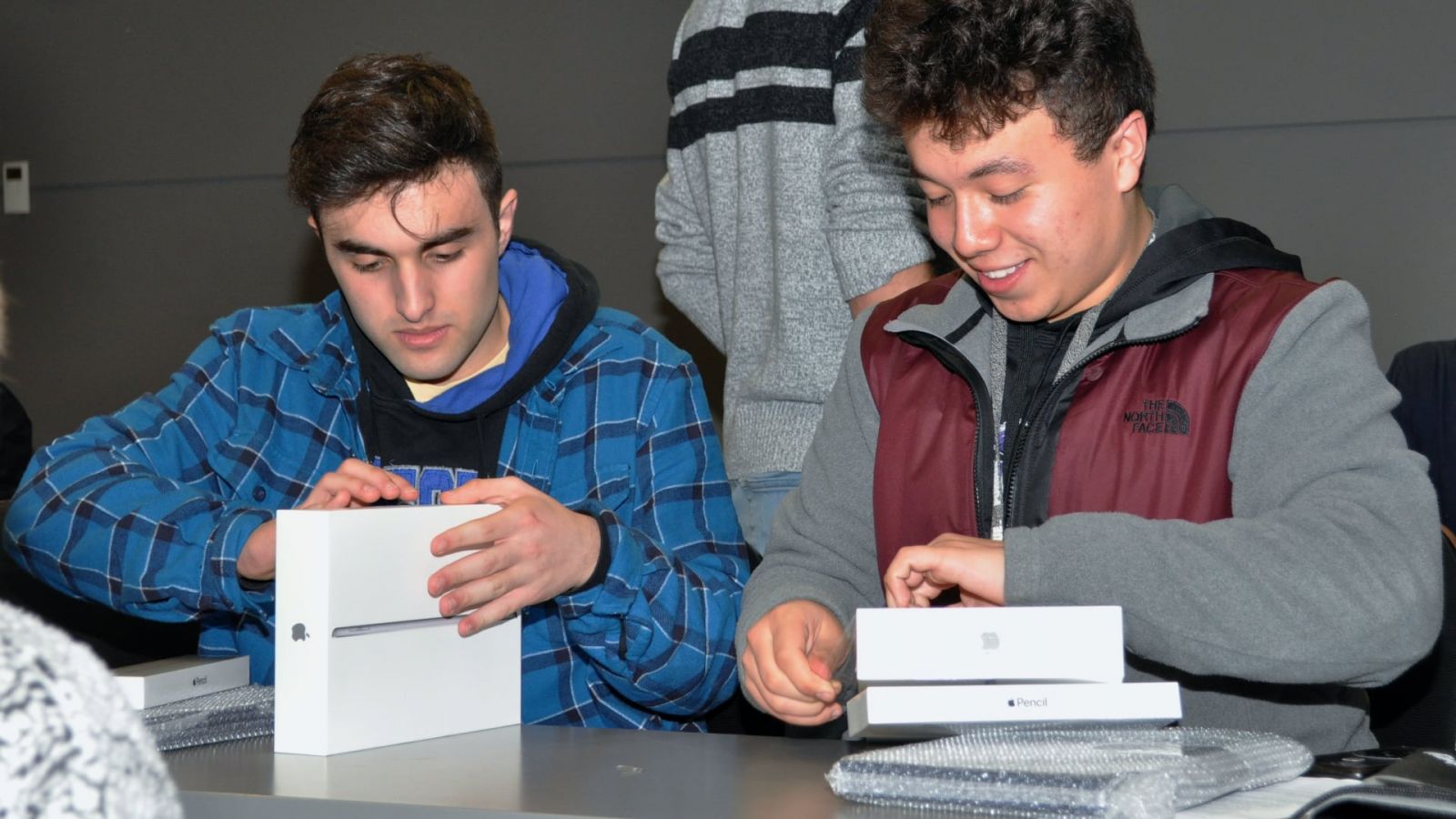 Aviation technology students each unbox their Electronic Purdue Bag's iPad and Apple Pencil