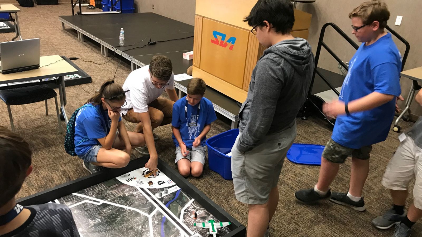 Jackson Otto (kneeling) works with K-12 students at Subaru of Indiana Automotive