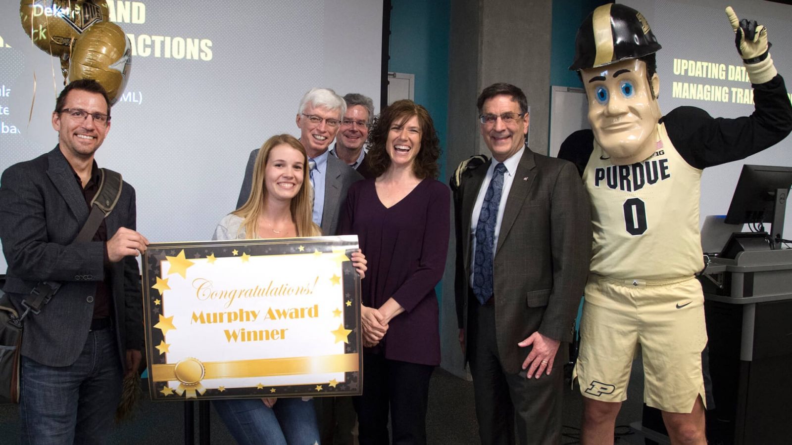 (From left) Chad Laux, associate professor of computer and information technology; Kayla Rux, student; Gary Bertoline, dean of Purdue Polytechnic Institute; Tom Hacker, interim head and professor of computer and information technology; Dawn Laux, Murphy Award recipient; Frank Dooley, senior vice provost for teaching and learning; and Purdue Pete. (Purdue University photo/Mark Simons)