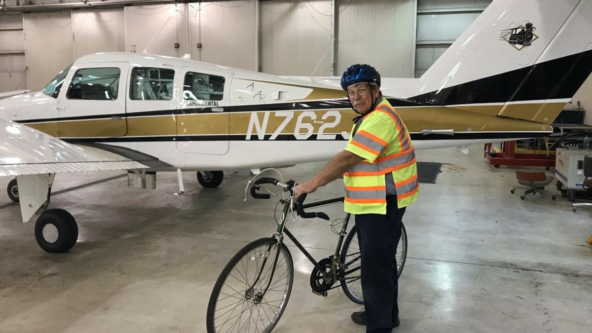Brian Stirm with his bicycle and one of Purdue's airplanes (Photo provided)