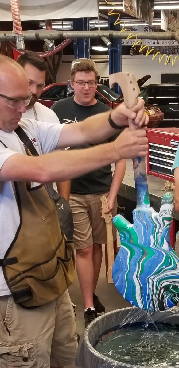 Dipping guitar bodies in paint floating on water coats them with a swirled pattern (Purdue University photo/Mark French)