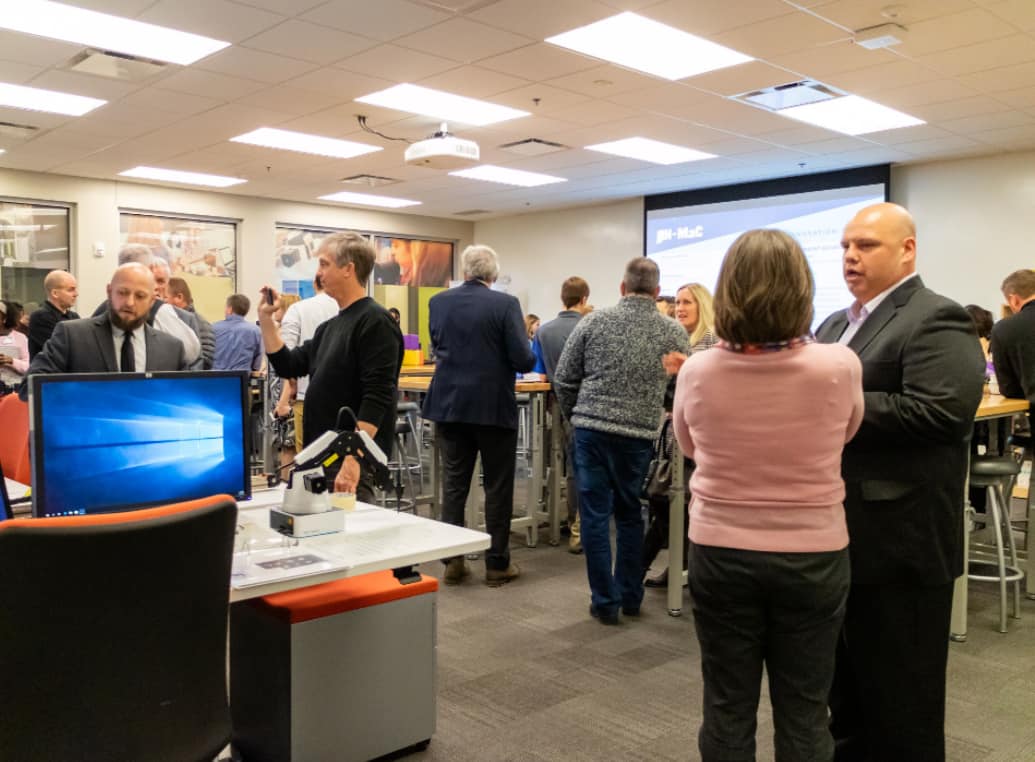 Nathan Hartman (right), Dauch Family Professor of Advanced Manufacturing at Purdue Polytechnic and co-executive director of IN-MaC, and Greg Strimel (left), assistant professor of engineering/technology teacher education, discusses the new IN-MaC Design and Innovation Studio with attendees.