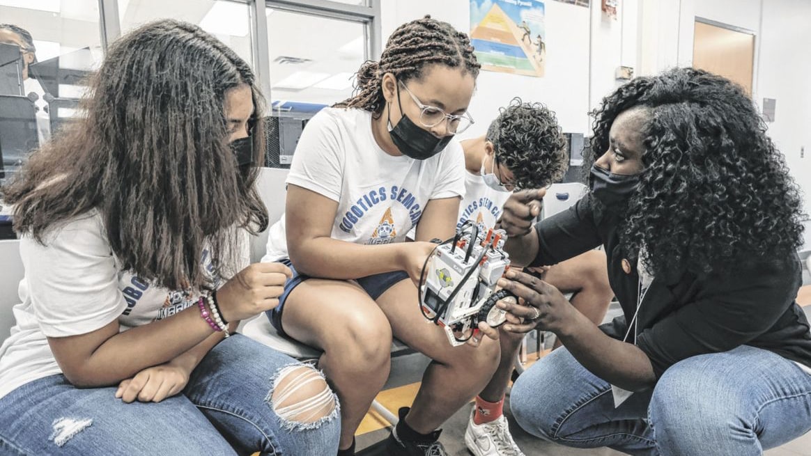Shannell Carroll, from left, and Miyanna Haywood talk with instructor Ebun Okuleye-Ashwatch during a robotics competition at a camp held by Purdue Polytechnic Columbus. (The Republic photo/Mike Wolanin)