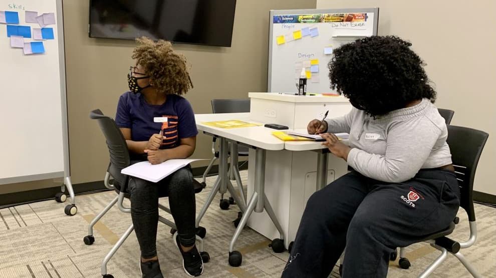 Lyric Clark, left, and her sister Alicia Smith watch a presentation during a classroom session that was part of a STEM enrichment program held at Purdue Polytechnic Anderson. (The Herald Bulletin photo/Andy Knight)