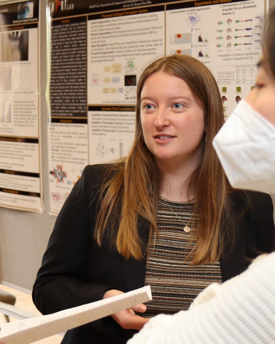 Janna Johns, an undergraduate UX (user experience) research lab assistant, discusses research projects with other students during a recent poster session in Stewart Center. (Purdue University photo/John O'Malley)