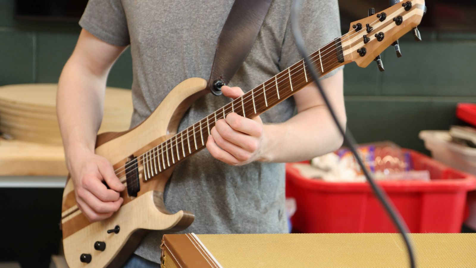 Gryphon Mawhorter plays his latest self-made guitar after re-stringing it.