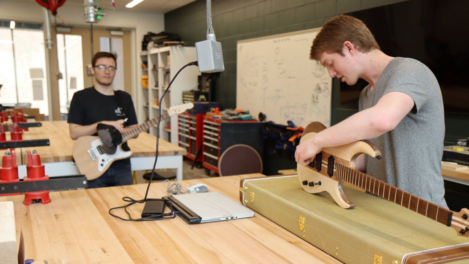 Ethan Fry (left) and Gryphon Mawhorter (right) discuss the details of Fry's guitar, built during Prof. Mark French's course.