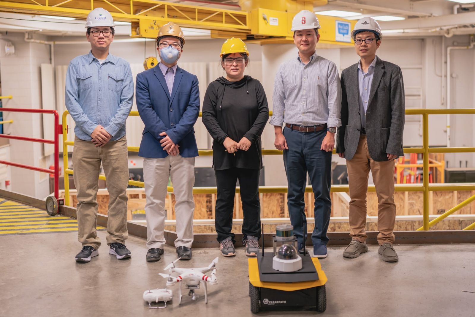 Left to right: Yifu Wu (graduate research assistant), Jiansong Zhang (co-principal investigator), Jin Wei-Kocsis (principal investigator), Byung-Cheol “B.C.” Min and Dongming Gan (co-principal investigators), standing in Knoy Hall’s D. Dorsey Moss Construction Lab with an unmanned aerial vehicle and an unmanned ground vehicle (Photo provided)