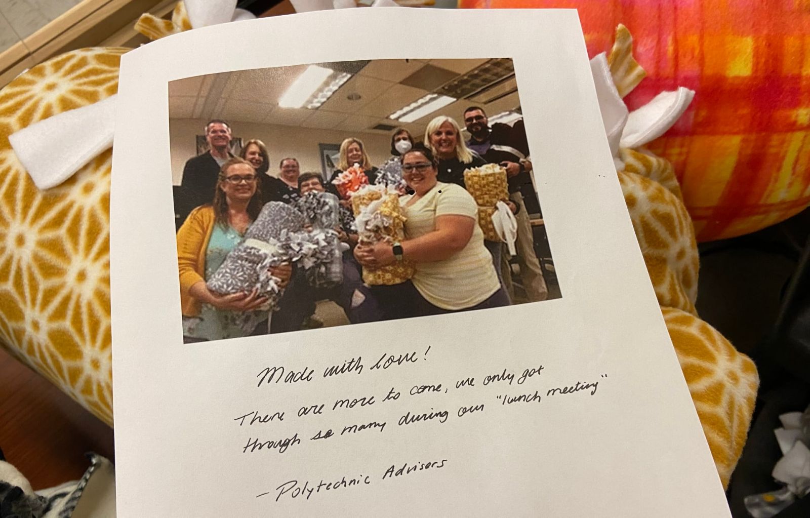 The Purdue Polytechnic Institute’s academic advising staff left a kind note for LaGrange atop their blanket donation. Pictured: Tami Lynch, T.R. Oneal, Aimee Griggs, Angie Murphy, Zach Oborne, Cassie Pendleton, Susan Hockings, Melody Carducci, Heather Mayorga, and Jill Lloyd-Crucini. The note reads, "Made with love! There are more to come. We only got through so many during our 'lunch meeting.' —Polytechnic Advisors" (Photo provided)