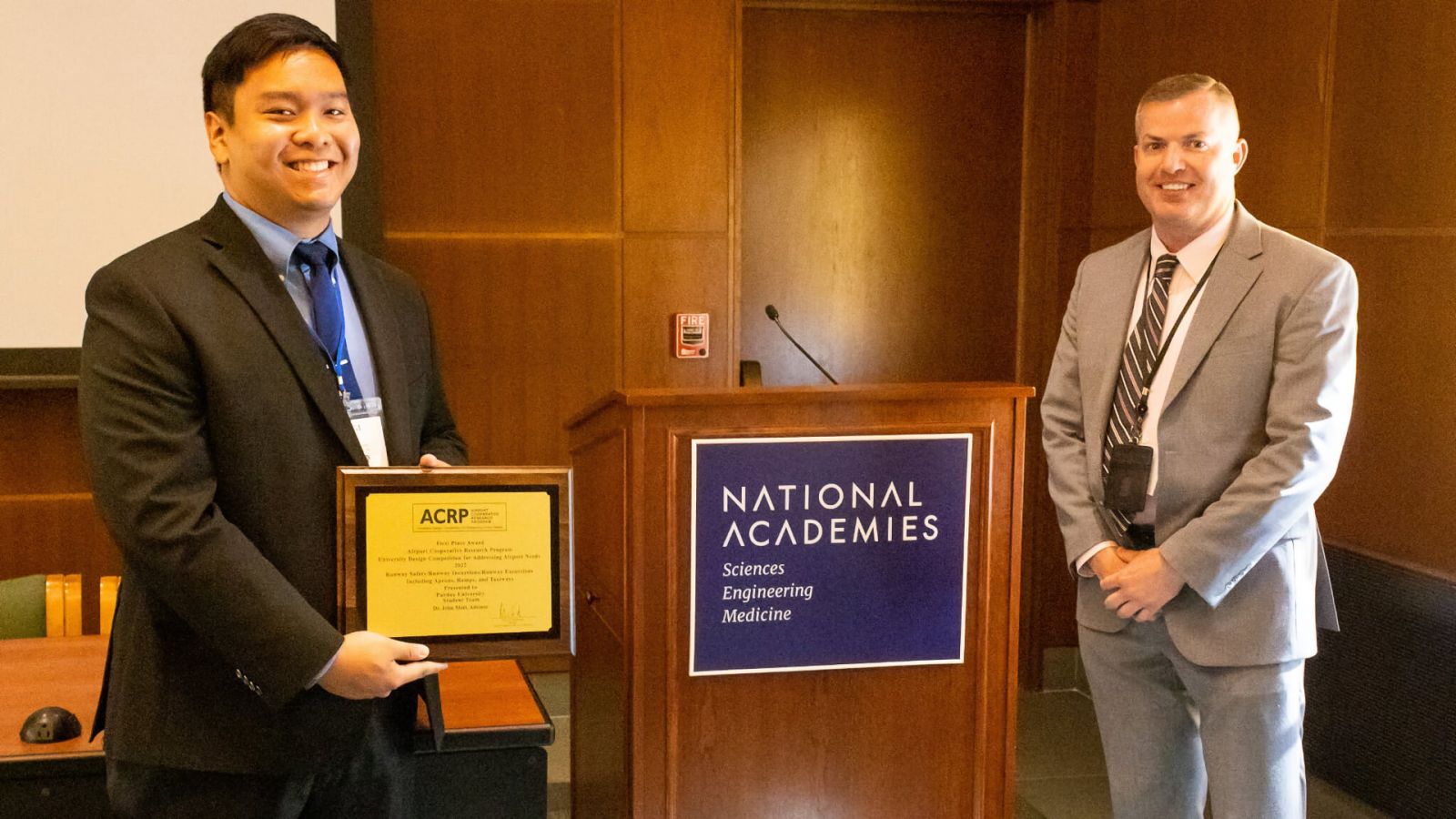 Luigi Dy (left), accepts the first-place award for the Runway Safety Challenge area in the Airport Cooperative Research Program's University Design Competition for Addressing Airport Needs from Joe Winingar, acting director of safety, Air Traffic Organization, Federal Aviation Administration (FAA) , at an award ceremony at the National Academy of Sciences building in Washington, DC.  (Photo courtesy of the Virginia Space Grant Consortium)