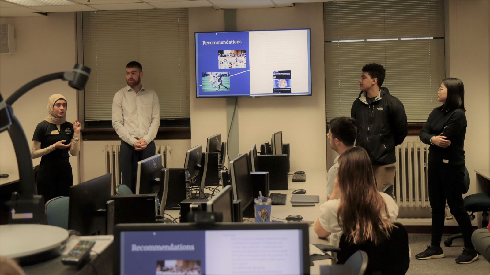 Polytechnic students Zahra Al-Awadi (left) and Devon Harmon (middle right) present with their group to Tom Brew of Boilermakers Country using a SWOT analysis.