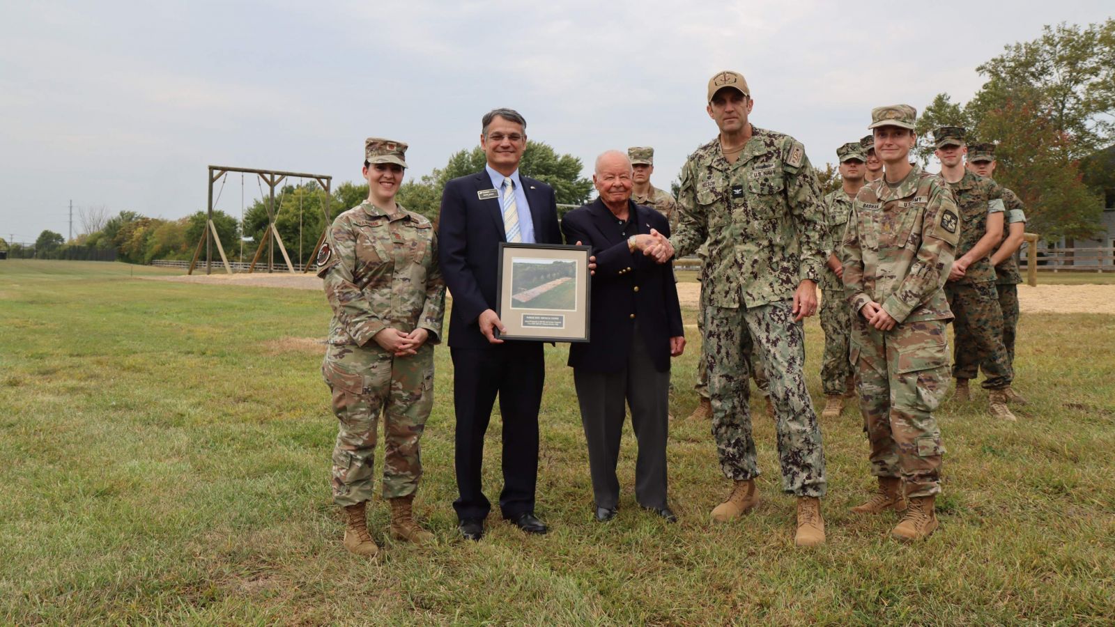 Purdue Polytechnic Dean Daniel Castro (left center) and Captain Christopher Nelson (right center) present Kasmark with a memento on the day of the dedication. Also pictured: Maj. Jessica Franklin, Maj. Amie Bashant, MIDN 1/C Dominic Giacomin, MIDN 1/C Ryan Getler, MIDN 1/C Carter Roach, OC Alexander Ozete.  (Purdue University photo/Nick Pompella)