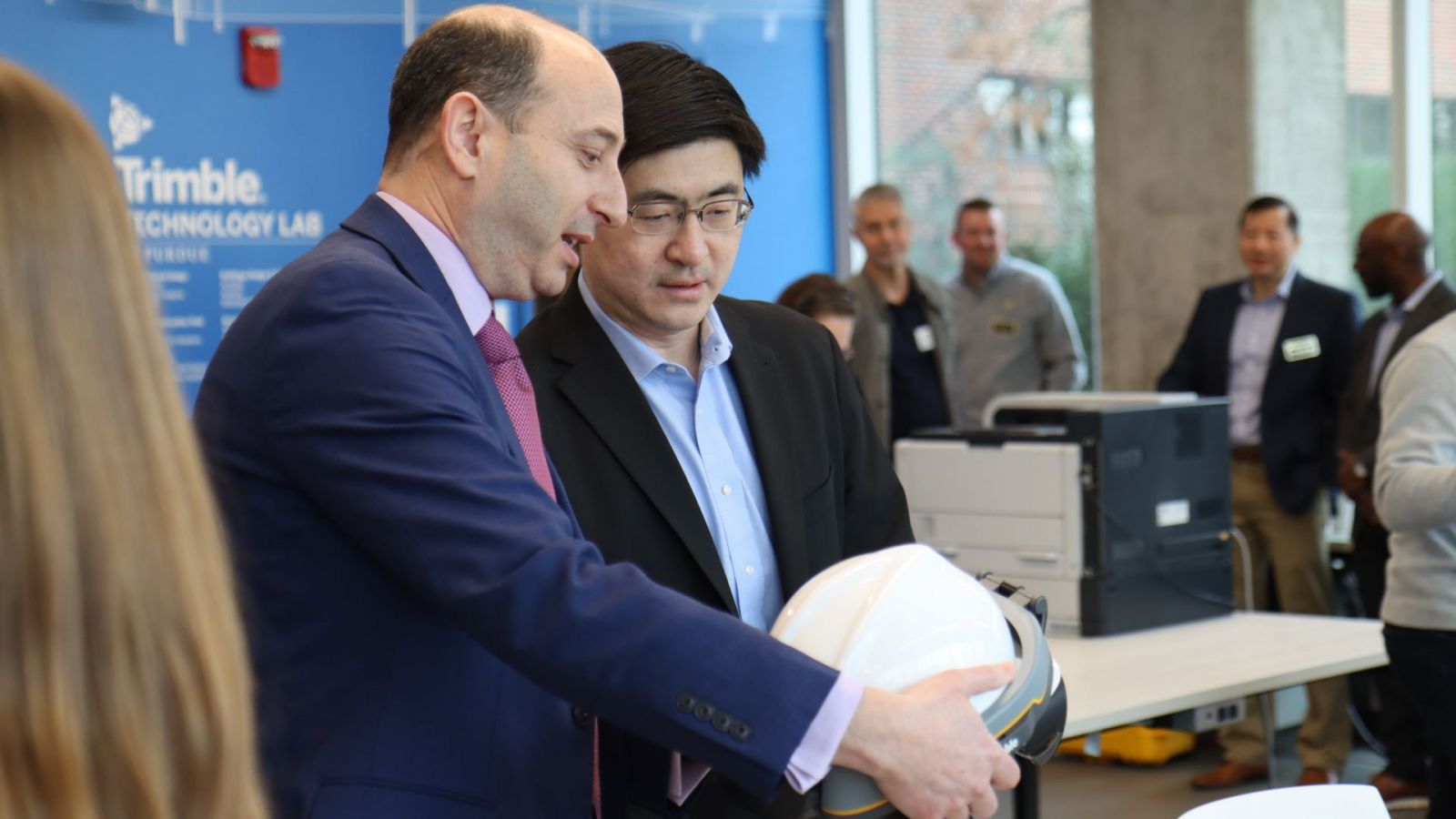 Purdue President Mung Chiang (right) speaks with Purdue's leading faculty contact for Trimble, Nicholas Dib, about how the company's software is used in extended-reality headsets. (Purdue University photo/Zach Rodimel)