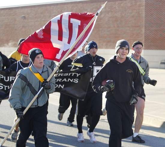 Bryan Morris of the Purdue Veterans Student Organization is joined Saturday by ROTC cadets from all three military branches as he runs the game ball to Ross-Ade Stadium.