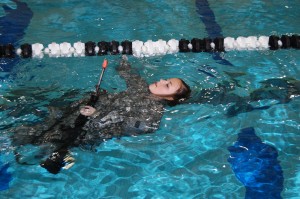 ROTC Training: a An ROTC cadet swims early Wednesday morning as part of required testing. The cadets jumped blindfolded from a 3-meter diving board while holding rubber guns, among other tasks.