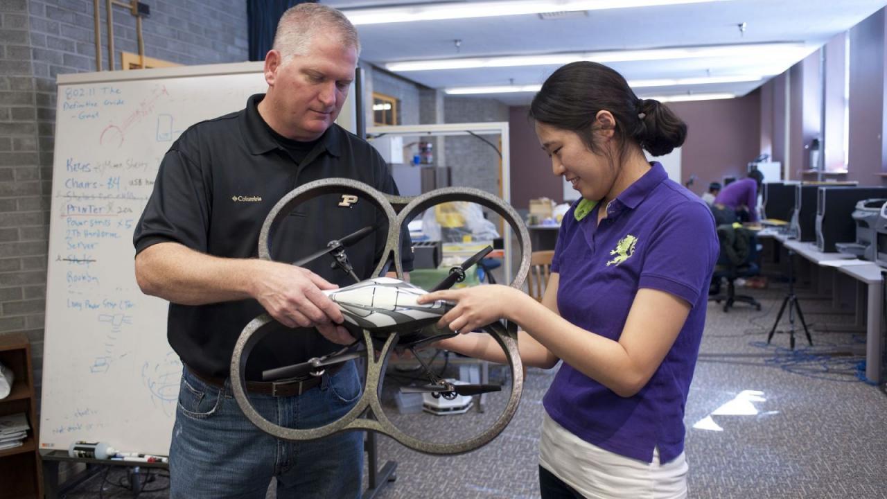 Eric Matson, recent award winner, assists a graduate student with an uncrewed aerial system unit. (Purdue University photo/Mark Simons)
