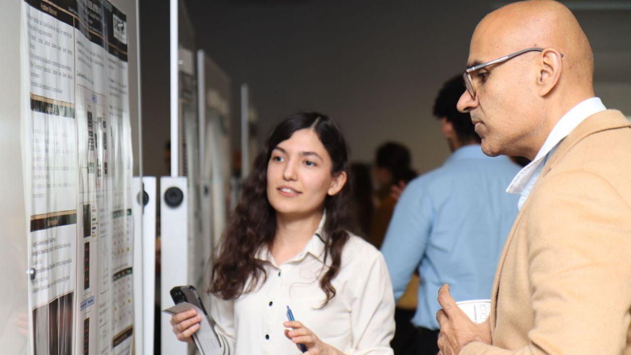 Guest speaker Navdeep Jaitly (right) speaks with a student about research during the Applied AI Day poster session. (Purdue University photo/John O'Malley)