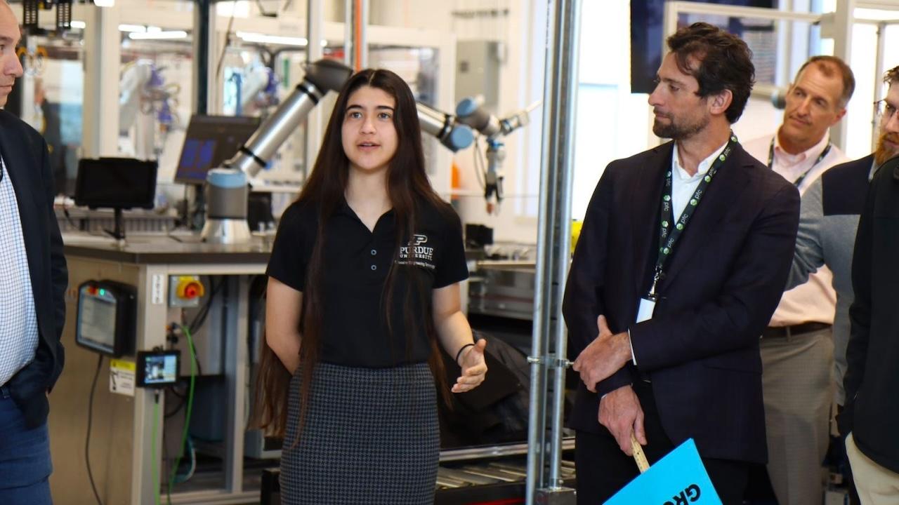 Dannalee Mata (left) and PTC vice president Serge Romano talk about this Smart Learning Factory with guests. (Purdue University photo/John O'Malley