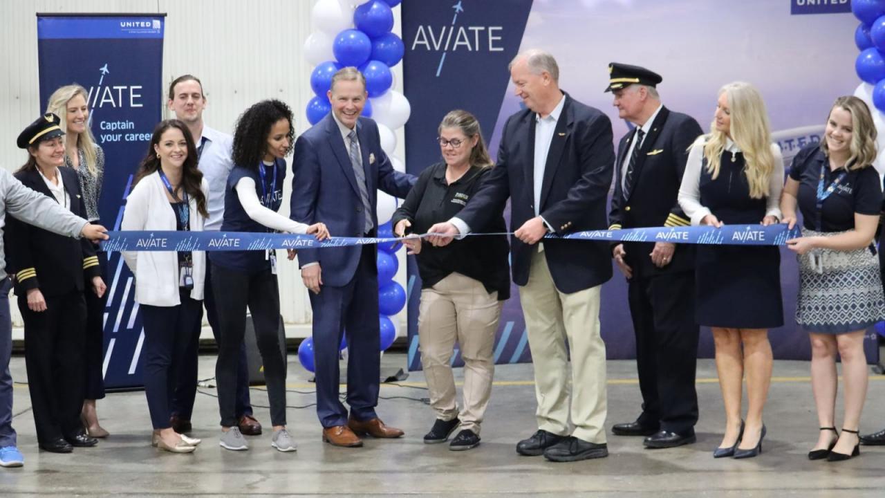 Officials from United Airlines and Purdue University celebrate a new partnership that will provide Purdue professional flight students a defined career path to a flight deck at United via the Aviate pilot career development program. Cutting the ribbon is Vicki Gilbert, recruiting and placement coordinator in Purdue’s School of Aviation and Transportation Technology. Holding the ribbon for Gilbert is Mike Suckow, clinical professor of aviation and transportation technology. (Purdue University photo/Zach Rodi