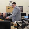 A demonstration of the physical and digital Safety Data Sheets. The digitized version designed by Polytechnic students (incl. Holden Tovey, right) promises quicker access and greater usability. (Photo credit: Melissa Casner)