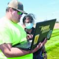 Aaron McCambridge, left, a student at Purdue Polytechnic Anderson, works with Rashmi Deodeshmukh, assistant professor of practice, near a farm field lab on which the institute is partnering with NineStar Connect in Hancock County. (Submitted photo)