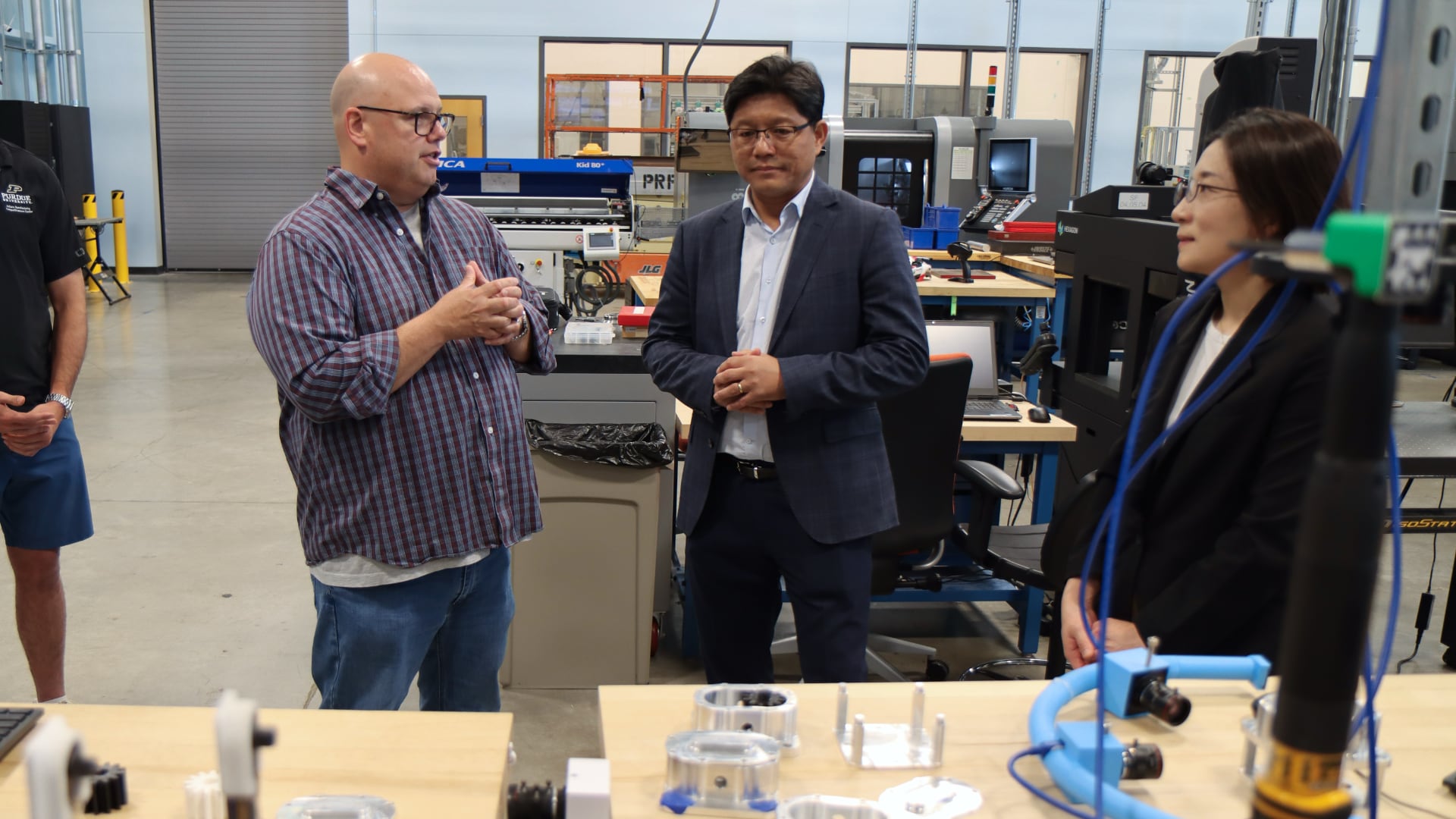 Nathan Hartman (left) discusses IN-MaC's design and testing capabilities with Seung Ki Moon (center) and Noori Kim. (Purdue University photo/John O'Malley)